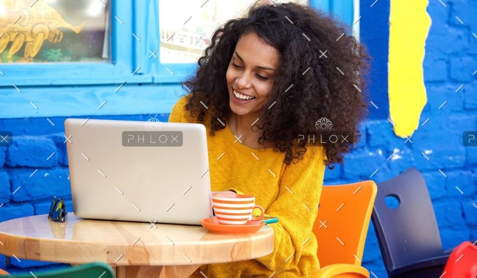 demo-attachment-65-happy-young-woman-sitting-at-outdoor-cafe-using-PFFBJ93
